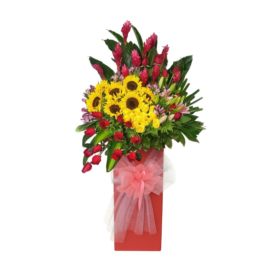 Grand opening flower stand featuring sunflowers and red roses, red ginger, and tropical leaves in a red box base, perfect for business launches in Singapore.