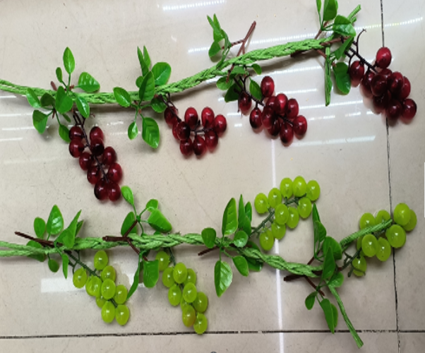Artificial green and red grape vines on a tiled floor