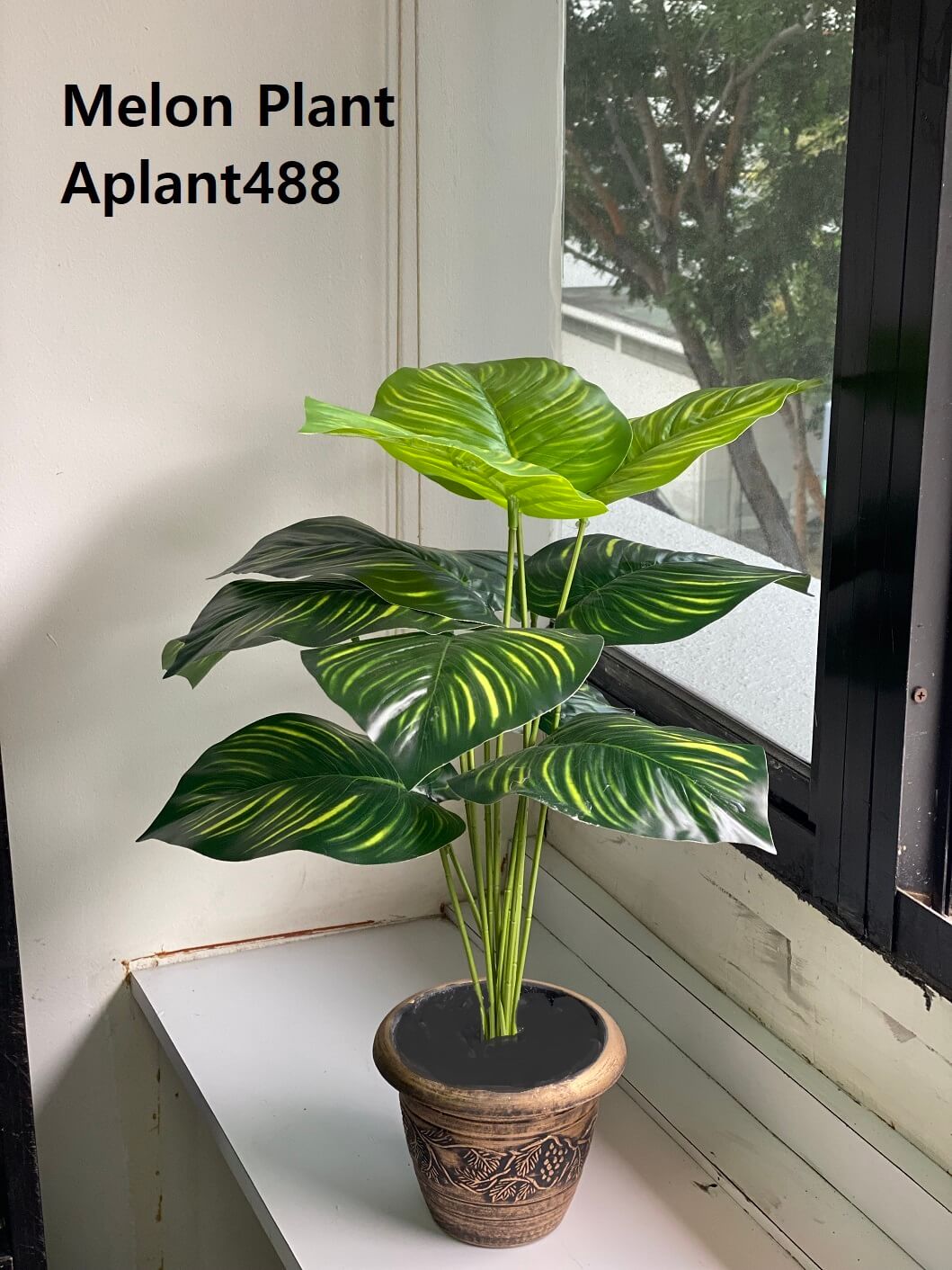 Artificial green Calathea Orbifolia or "Melon Plant" with prominent yellow-green stripes and a glossy finish, set in a decorative gold-toned pot for indoor decor.