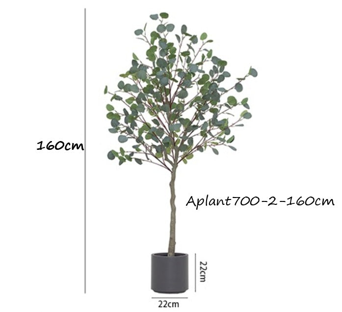 Potted artificial eucalyptus tree with round green leaves in a light beige pot, placed indoors.