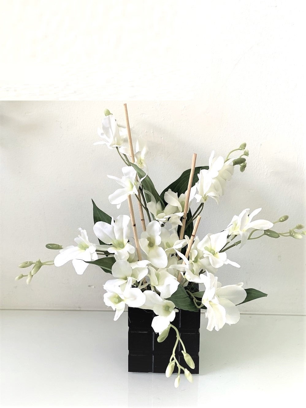 All-white artificial orchid flower arrangement by Alton Flowers, showcasing delicate orchids in a stylish display.
