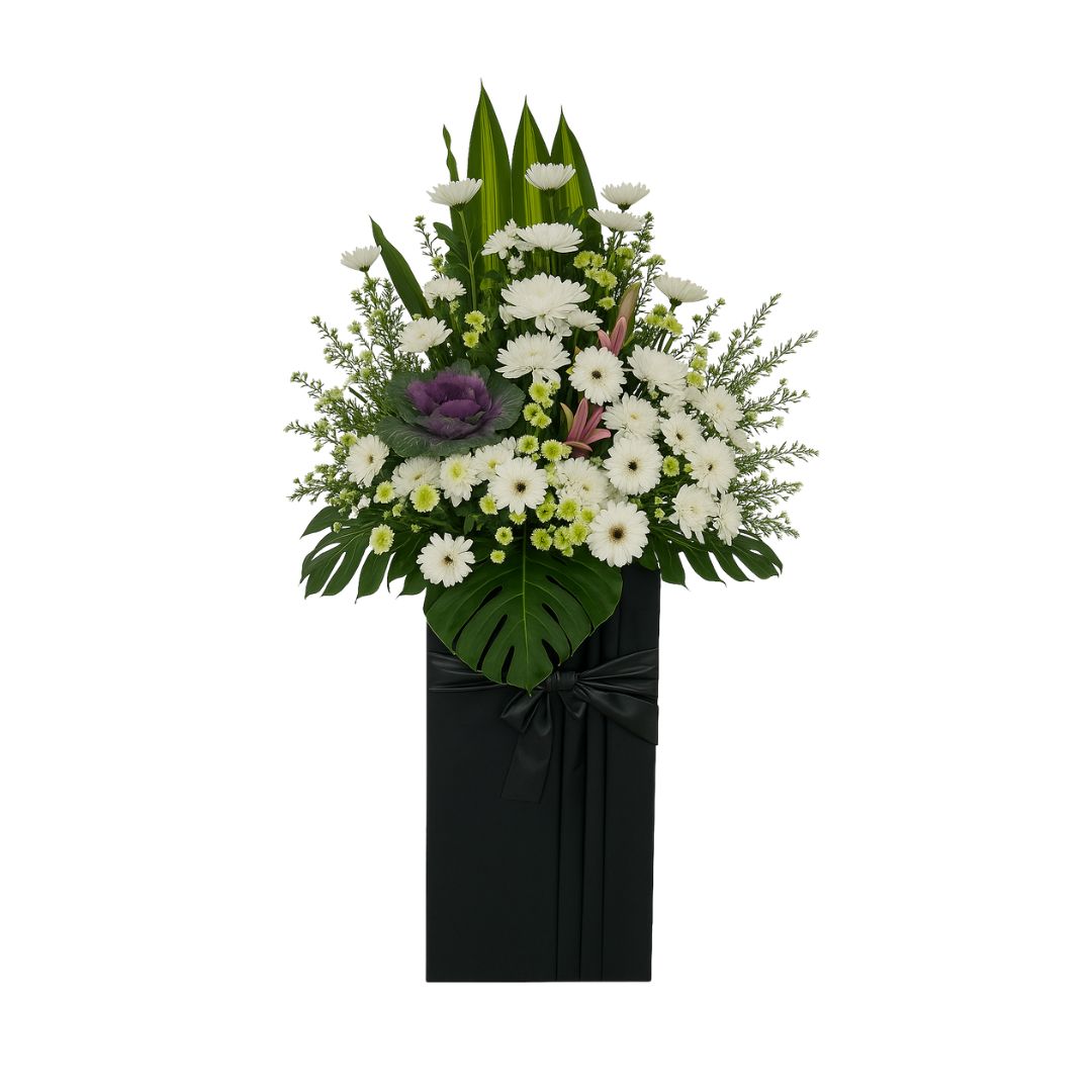 Floral condolences arrangement in a black container on a white background