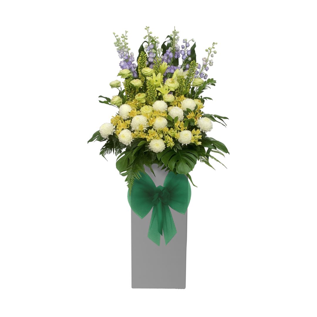 Bouquet of condolences flowers with a green bow on a white background