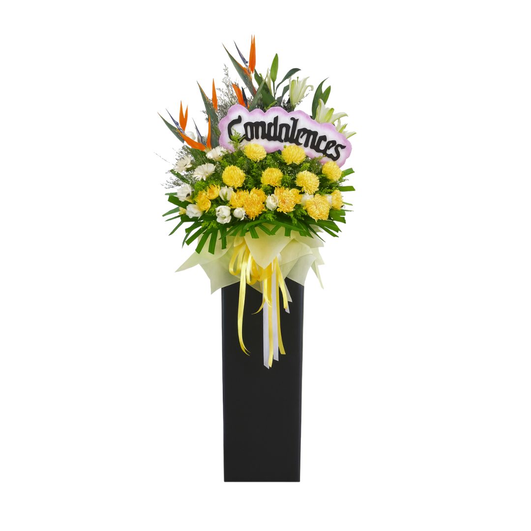 Floral condolences arrangement with 'Condolences' sign on a white background