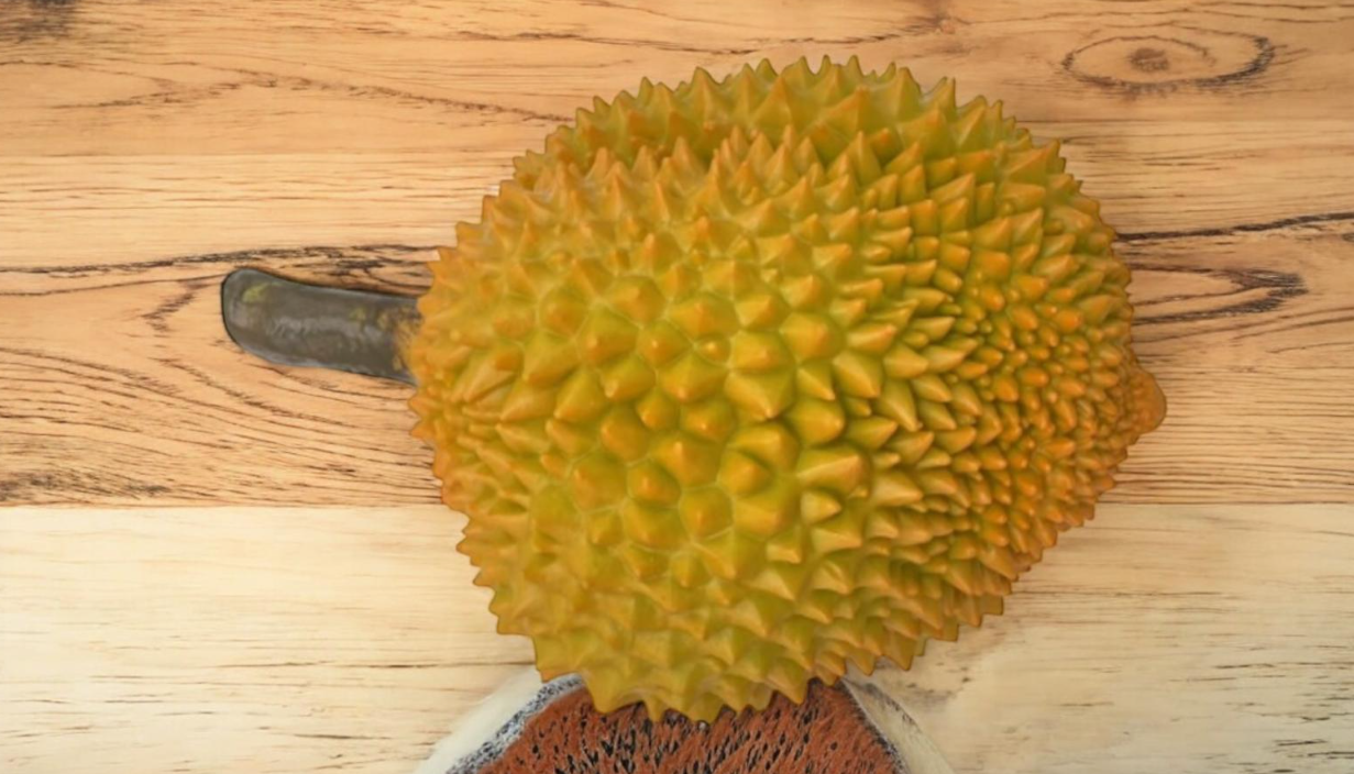 Spiky artificial durian fruit on a wooden surface