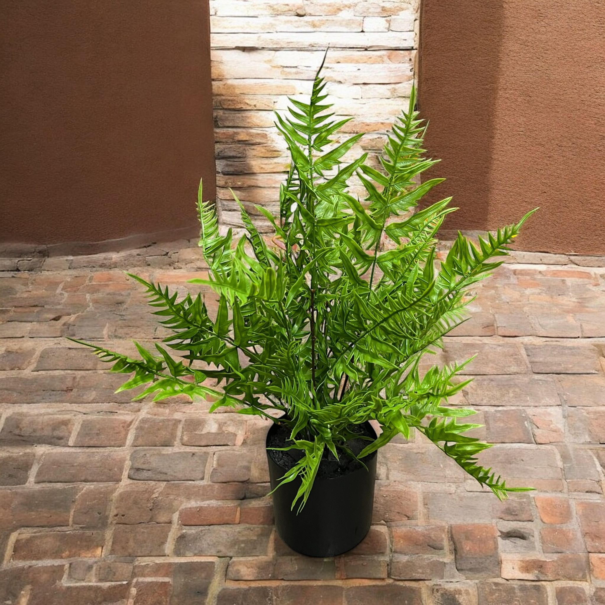 Artificial green fern plant in a black pot, suitable for indoor or outdoor home decor.
